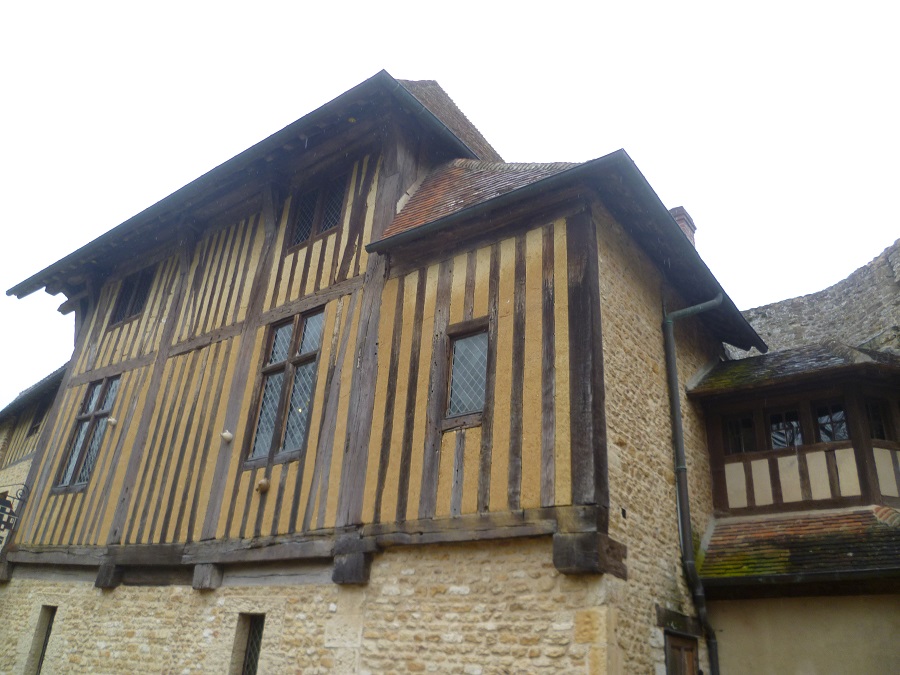 Looking up to half-timbered manor of Crevecoeur showing wooden facade on stone building