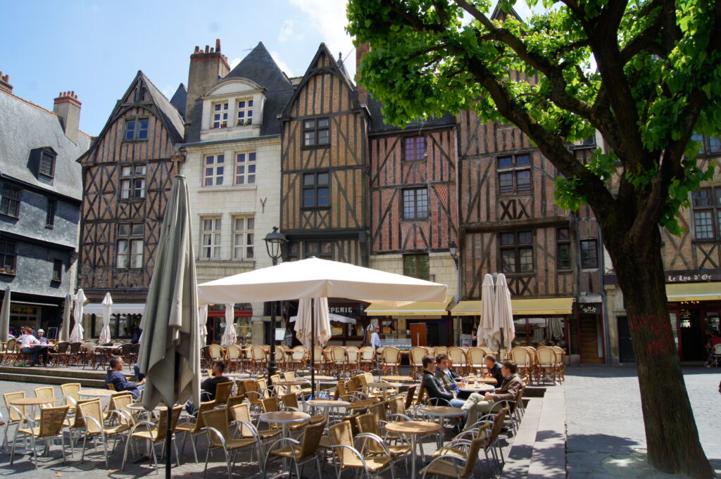 Tours in the Loire Valley, main square with empty tables and chairs in centre surrounded by old half-timbered tall houses