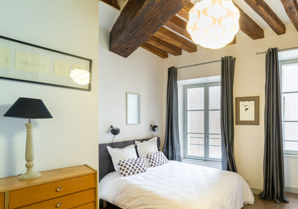 Maison de Thomas chic bed and breakfast in Blois. Showing one room with old beamed ceiling, double bed with crisp white sheets and window