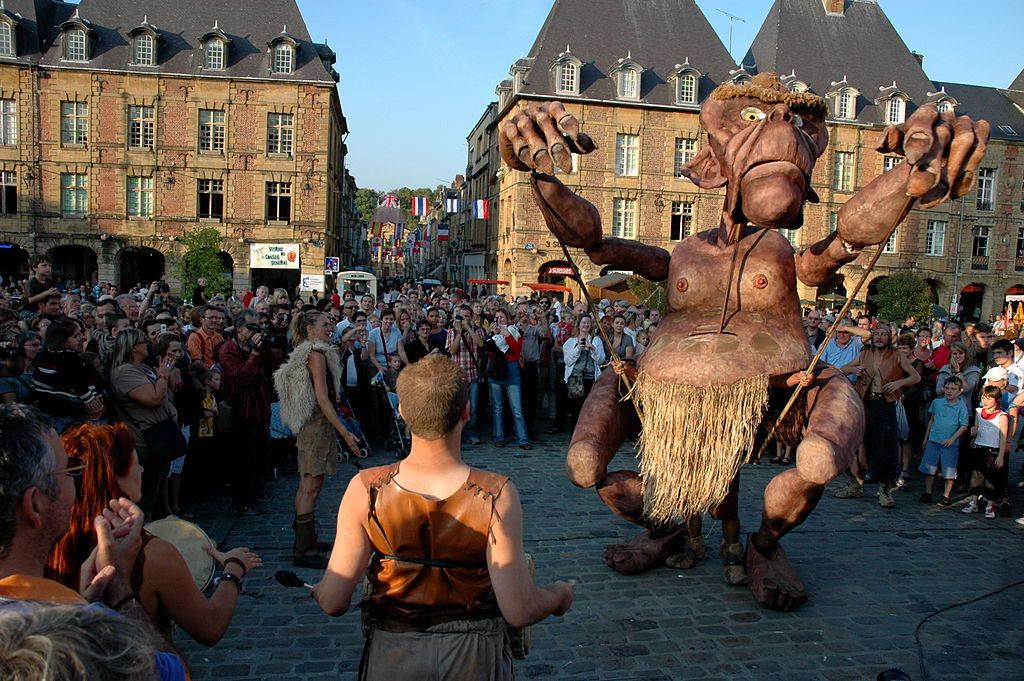 Street puppet festival showing giant puppet un square surrounded by crowds
