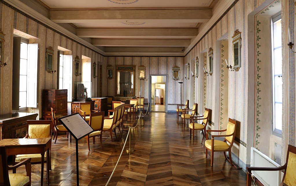 Napoleon's house in Ajaccio interior of long gallery with chairs regimented on one side and furnishings on other. Polished wooden floor