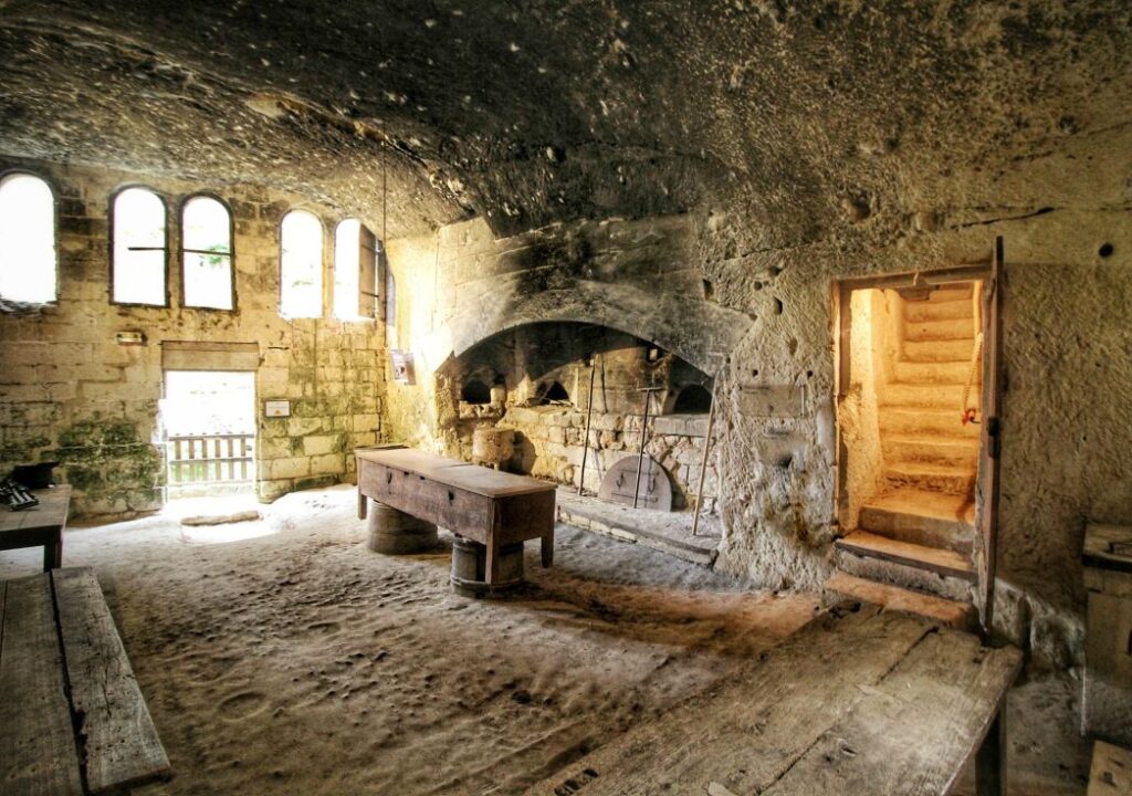 Château de Brézé Loire Valley underground kitchens showing vaulted stone caves with tables and stairs leading out