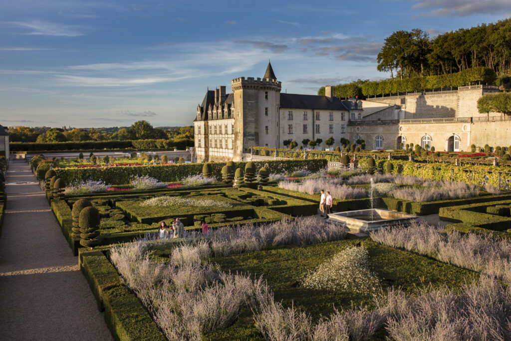 Chateau de Villandry at sunrise showing chateau in one corner with wall leading off to right and gardens formally laid out in Loire Valley