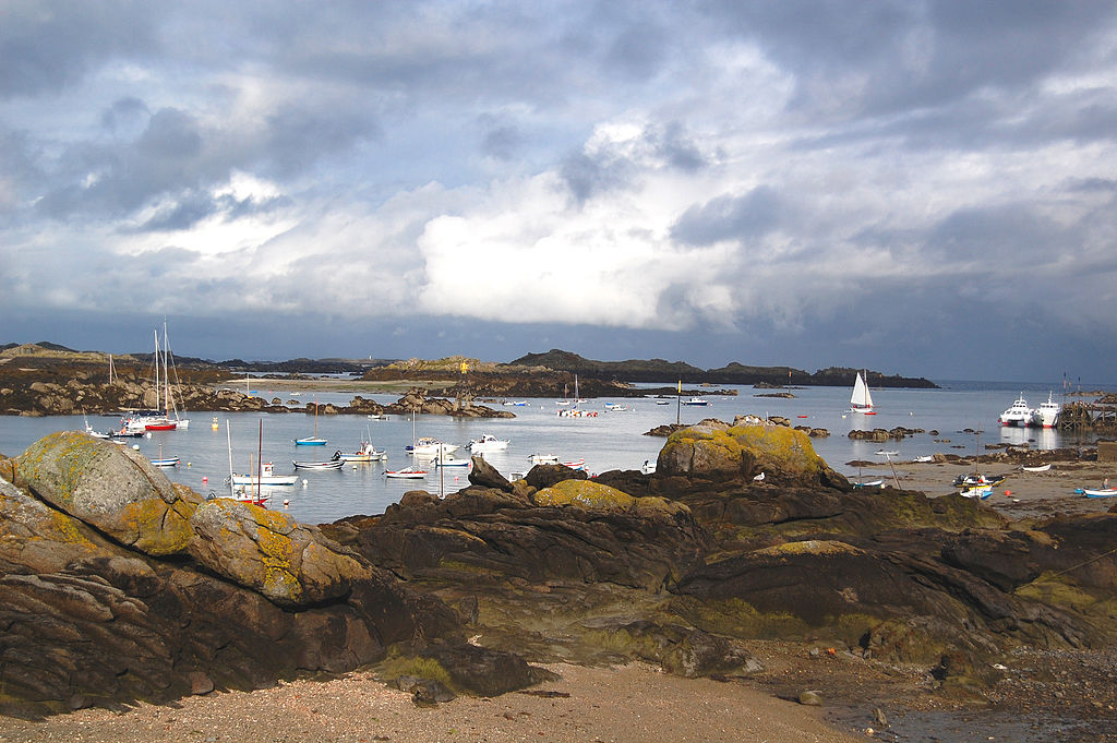 Chausey archipelago in Normandy islands of France showing stormy sky and rocks surrounding bays with yachts