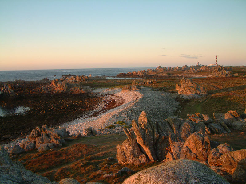 La Ponte de Pern Ouessant Brittany islands showing sunset/sunrise over sea to left, beach and rocks