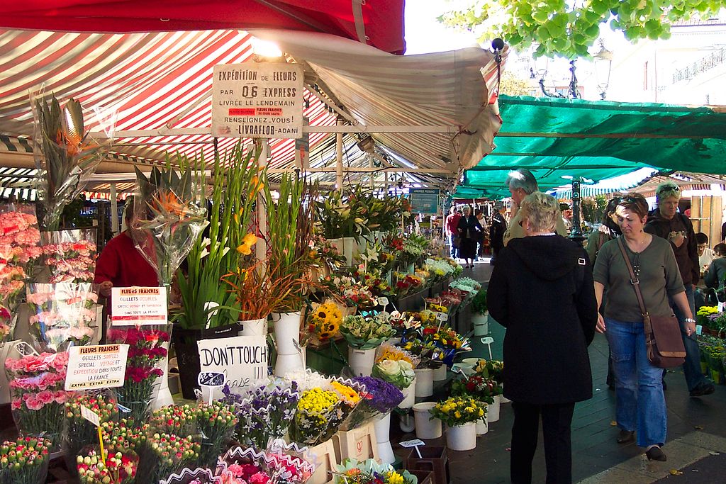 Cours Saleya market showing flower stands with woman in middle