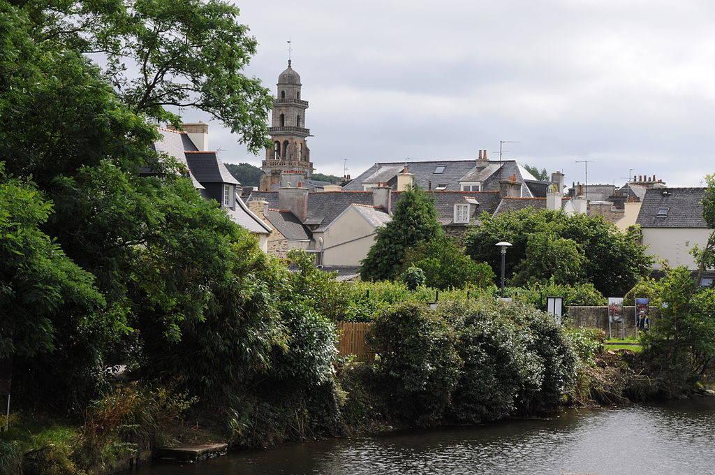 St Thomas church spire seen from distance over green hedges in Landerneau Brittany