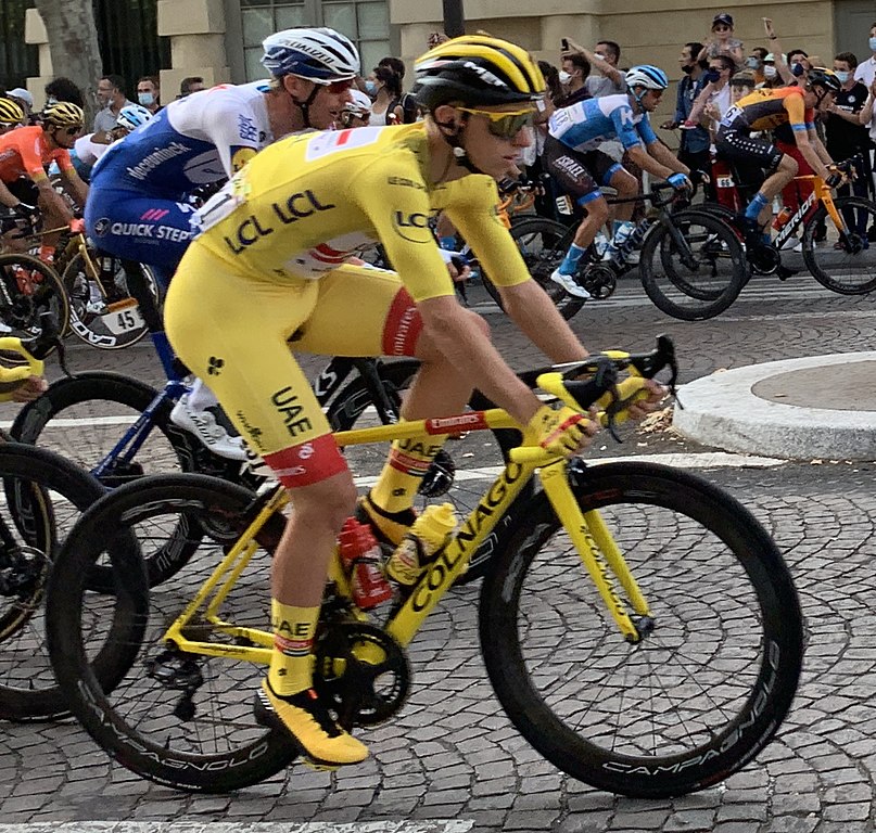 tour de France 2020 Tadej Pogacar winner in yellow jersey in Paris riding over cobbles with others beside him