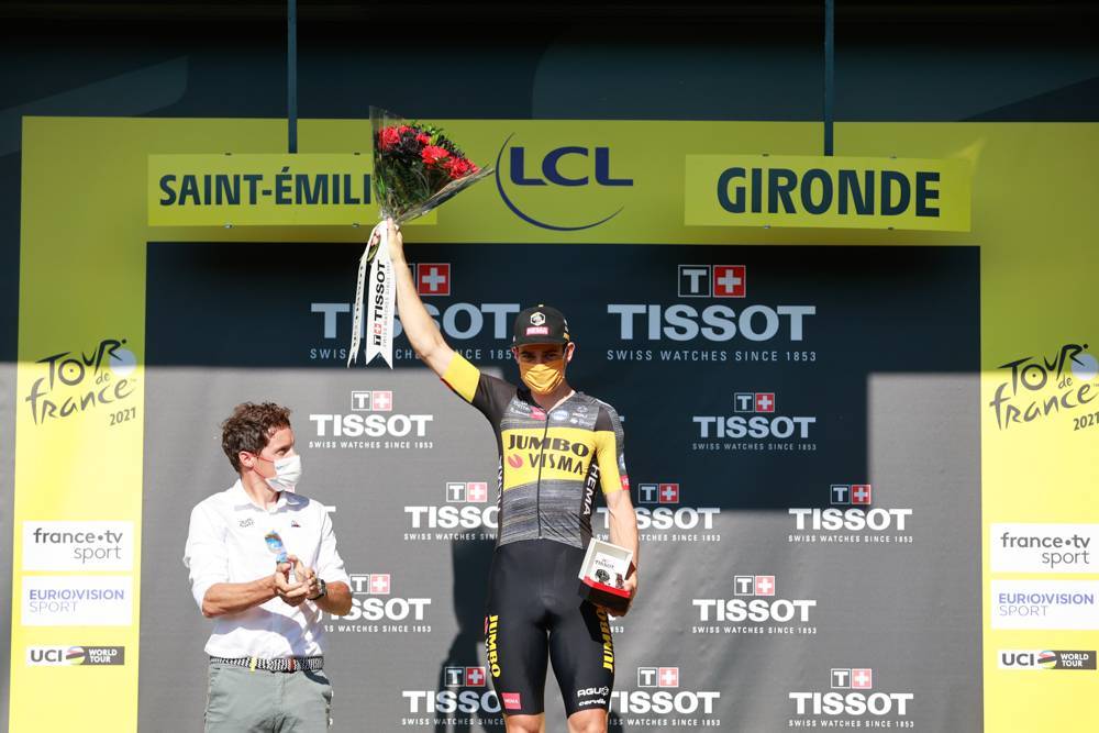 Tour de France 2021 Wouf van Aert on stage holding up flowers