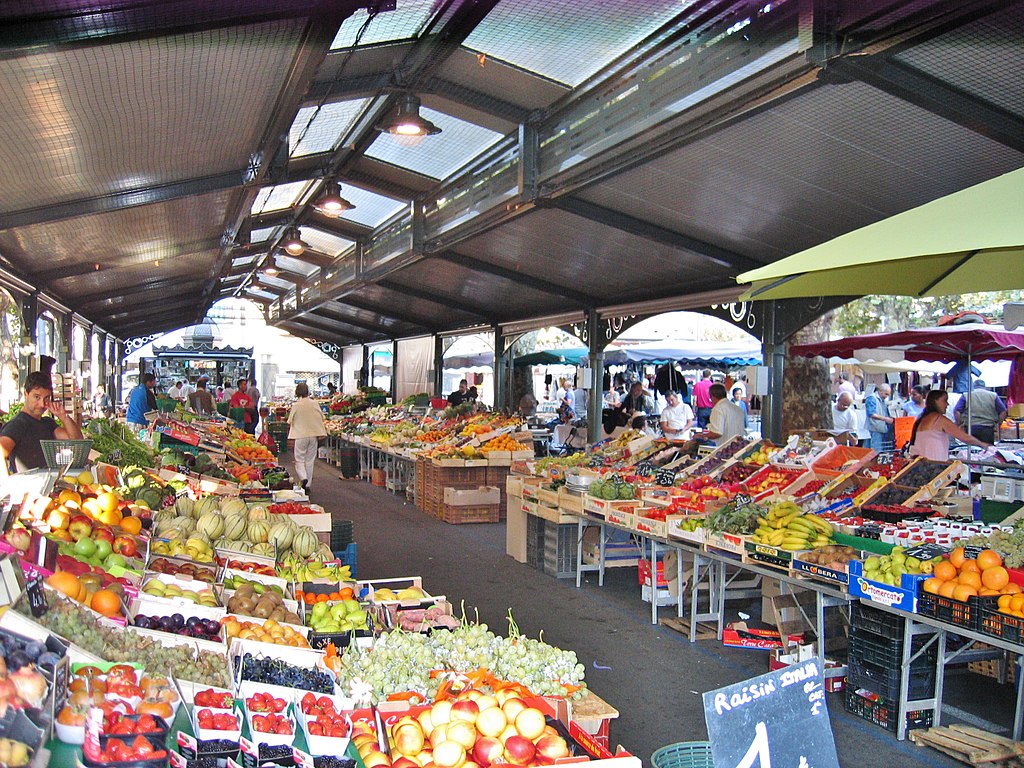 Cannes Gambetta Provence market looking down long aisle in covered section with fuit and vegetable stalls at either side