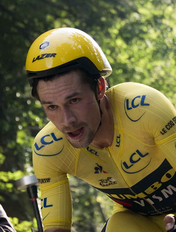 Close up of Primož Roglič at Tour de France 2020 with upper body on bicycle, dressed in yellow jersey looking determined