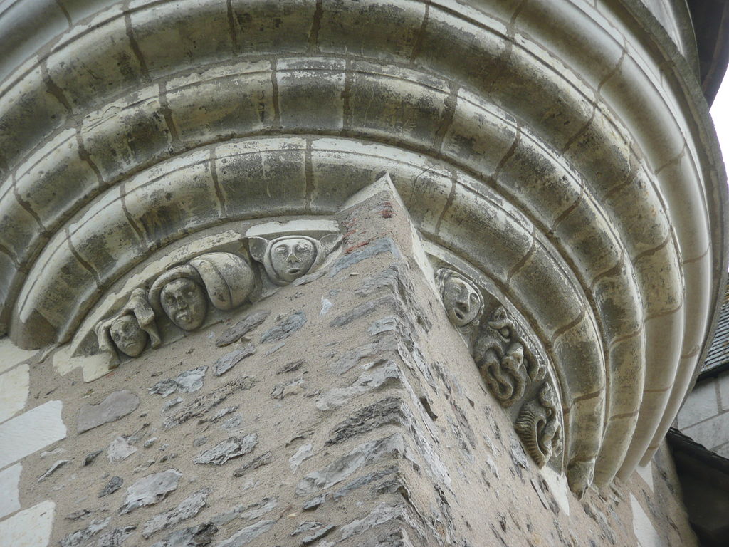 Château de Baugé looking up at round tower with faces carved into stone
