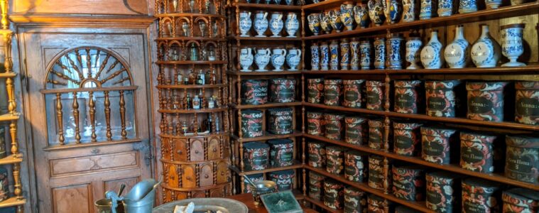 Bauge Loir Valley medieval apothecary showing shleves stacked high with bottles, pots etc of ancient medicines