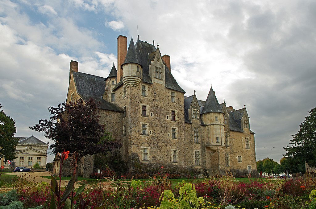 Chateau de Bauge in Loir Valley with stormy sky and huge chateau with conical towers and rooves and gardens in front