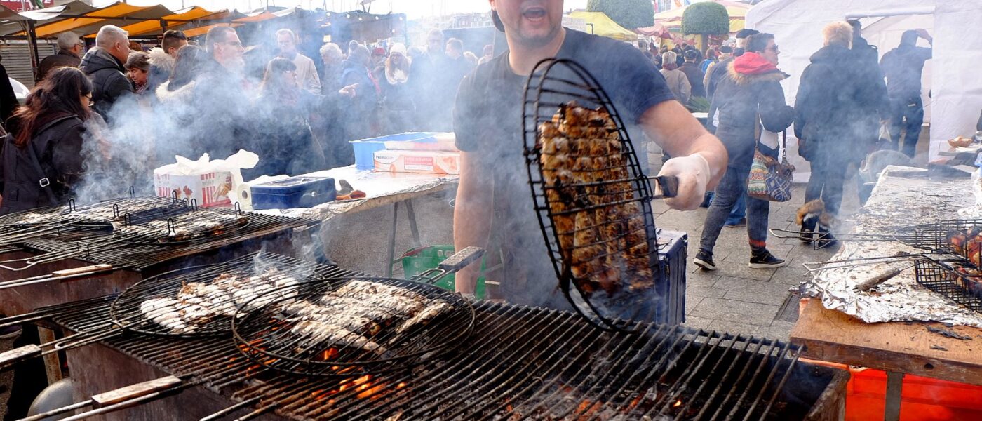 Herring Festival Dieppe with man cooking herrings on grill over fire