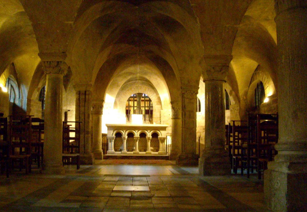 Crypt of Notre-Dame de la Couture Le Mans with huge Romanesque arches and altar at end lit up