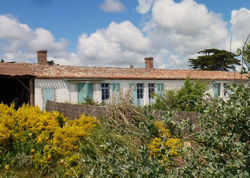 Modest house of Georges Clemenceau showing one storey cottage syle building with red roof tiles and blue shutters and doors in a garden
