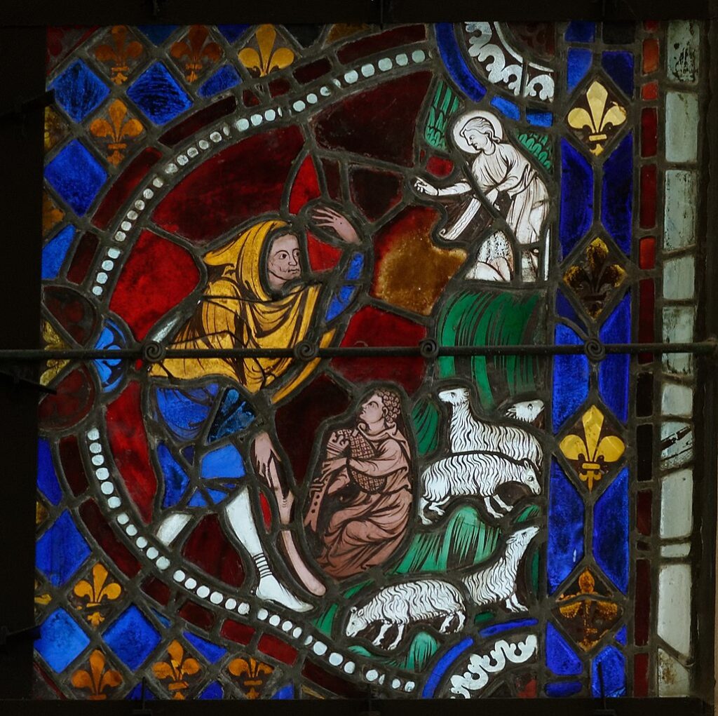 Detail of stained glass window in Saint Sulpice de Fabrieres with shepherd and lambs on right, angel above and traveller in medieval costume