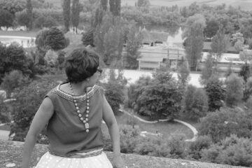 Black and white photo of Josephine Baker in dress on balcony overlooking countryside