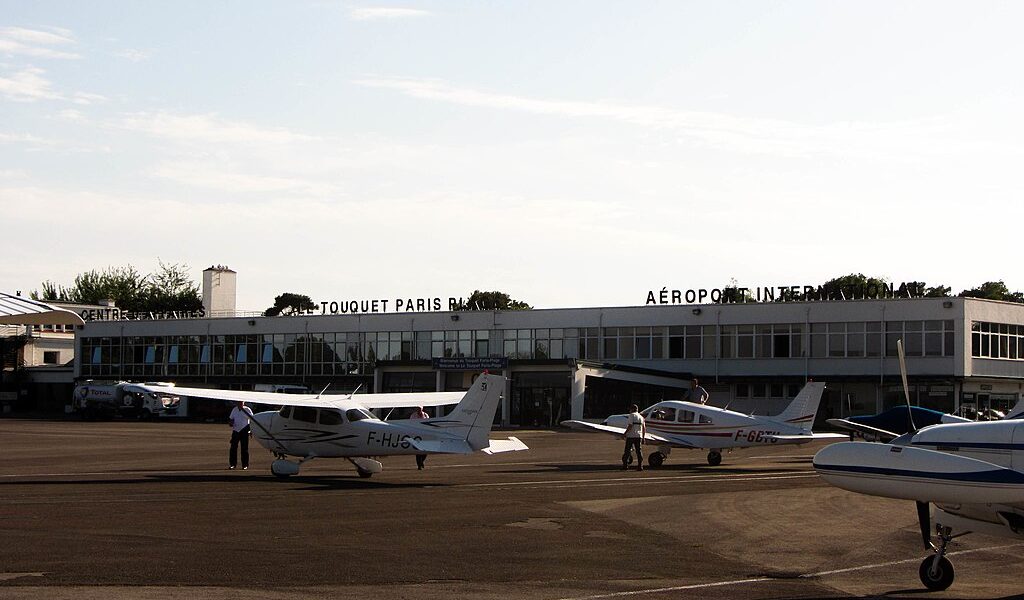 Le Touqet Paris-Plage airport with small planes with propellers in front of low airport buildings