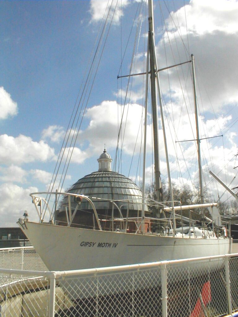 Gipsy Moth permanently moored at Greenwich in concret with round tower behind