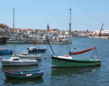 Les Sables d’Olonne port with small boats in front and old tow ehind with high church tower