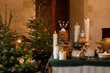 Azay-le-Rideau at christmas with table laden with candles and covered with greenery and christmas tree beside