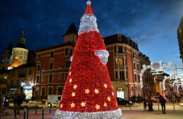 Huge illuminated Father Christmas in darkened square in