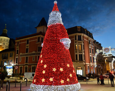 Huge illuminated Father Christmas in darkened square in