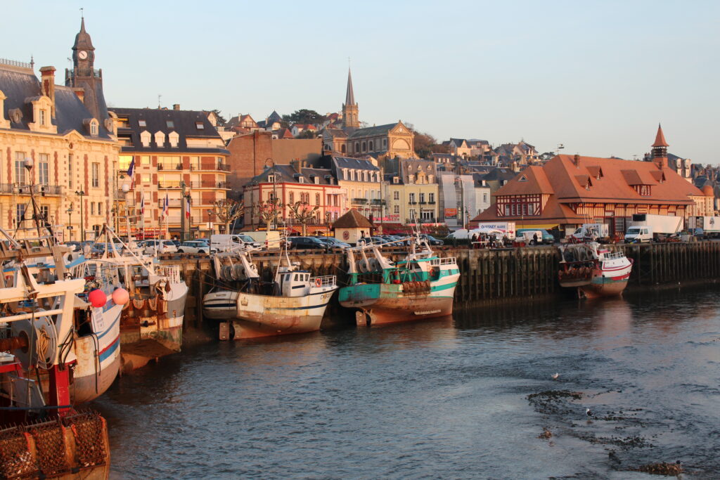 Fish market Deauville/Trouville with boats in water, market behind and old buildings in distance
