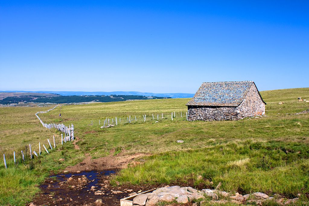 Aubrac Plateau in summer showing high desolate landscape with a stone shelter buron to one side