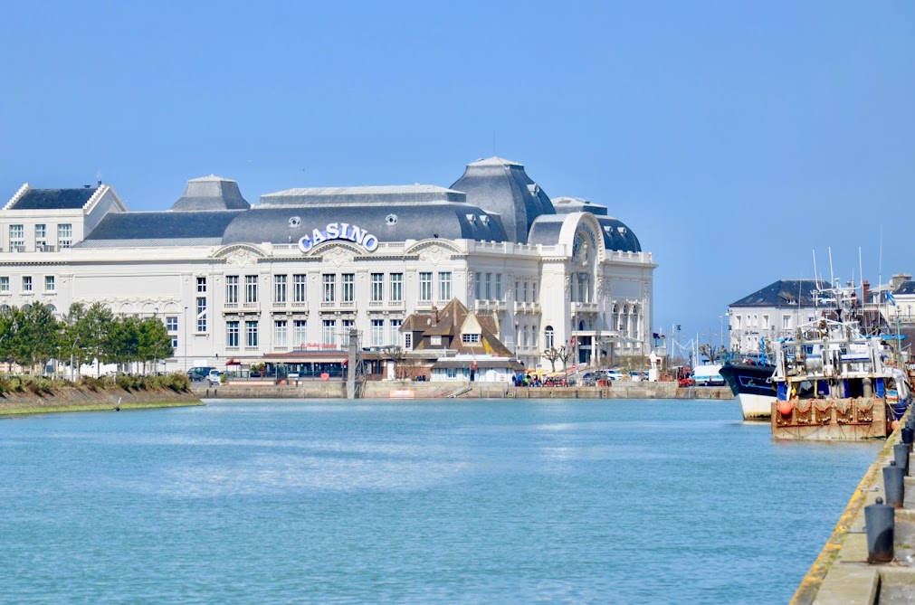 Casino at Deauville showing grand white 3 storey building in background with sea in front