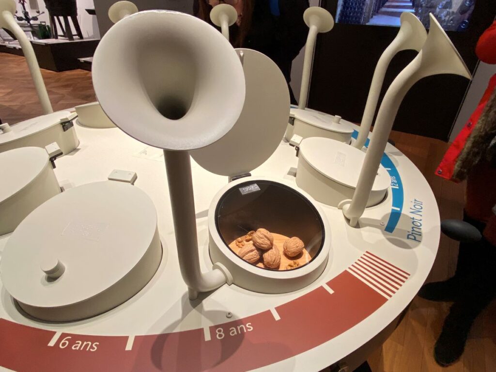 table with odd shaped funnels coming out for sniffing perfumes at epernay museum with round box of walnuts beside