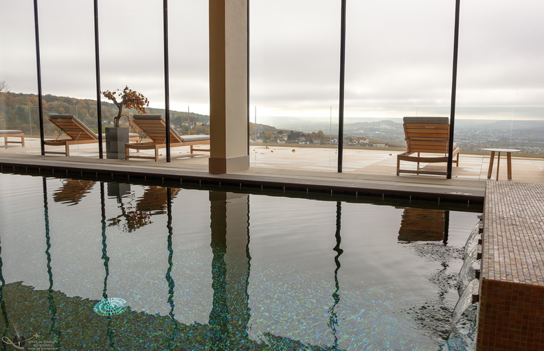 Royal Champagne Hotel spa looking over pool to floor to ceiling windows with terrace outside and view over vineyards