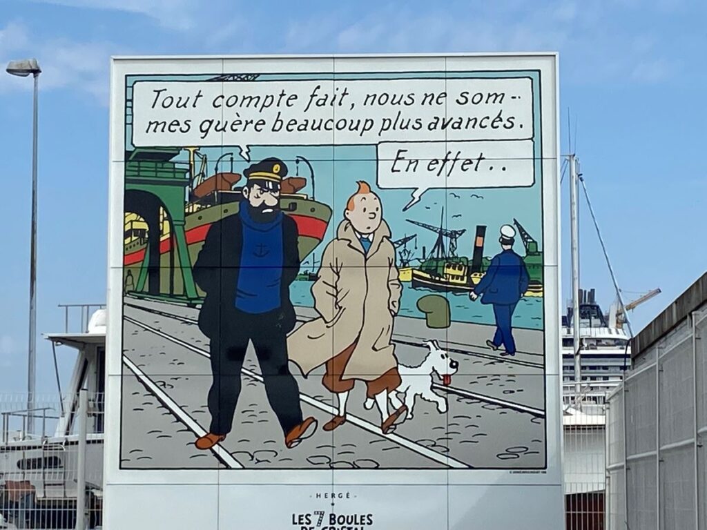 Big Tintin poster showing Captain Haddock and tintin walking along quay in Saint-Nazaire with big ship behind