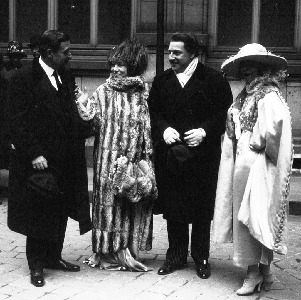 Sacha Guitry at his wedding to Yvonne Printemps, 1919, with Sarah Bernhardt to right all wearing top clothes and hats in old black and white photo