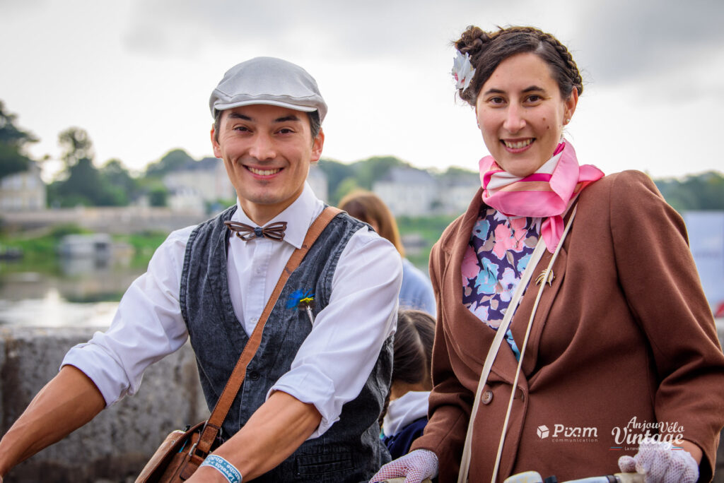 Saumur vintage cycle ride showing two people man and woman dressed in 1940s-50s style sitting on bicycles