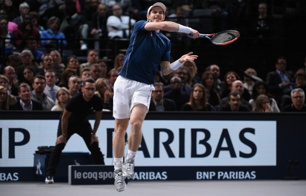 Rolex Paris Masters tennis tournament showing one man playing in white shorts and blue top against audience backdrop and large sign with Parisbas written on it