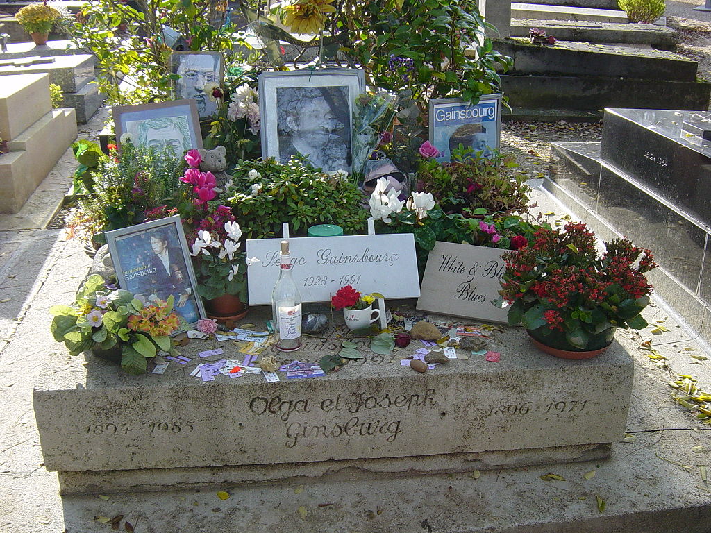 tomb of Serge Gainsbourg in Montparnasse cemetery with plaques with name, pictures and flower tributes