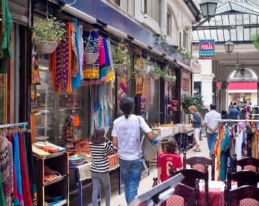 Brady Passage in Paris showing old passage with shops with dressed hanging outside and people walking down middle