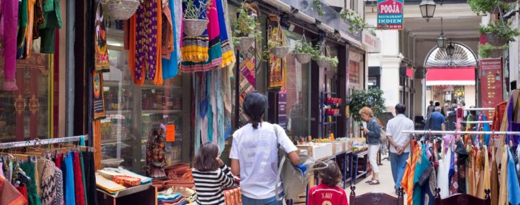 Brady Passage in Paris showing old passage with shops with dressed hanging outside and people walking down middle