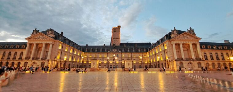 Place de la liberation Dijon long shot in orange light with palace of the dukes in background with windows lit up and big tower behind
