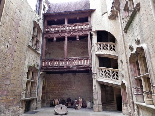 Hotel Le Chambellan, Dijon showing small courtyard with Renaissance stone staircase to right, wooden balcones in middle and old stone house windows on left