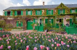 Monet's house at Giverney with front of house with green shutters and flowers in front