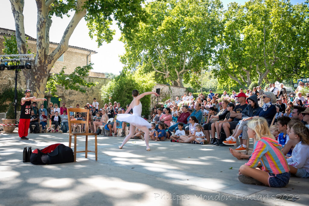 Font des Arts festival with ballerine in white tutu performing in street with crowd around and trees
