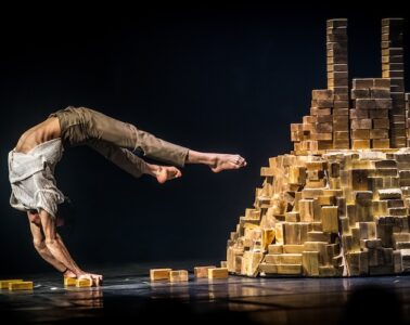 Festival of the Circus of Tomorrow with one acrobat extended backwards by pile of bricks