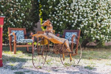 Antique metal rocking horse on wheels in open air