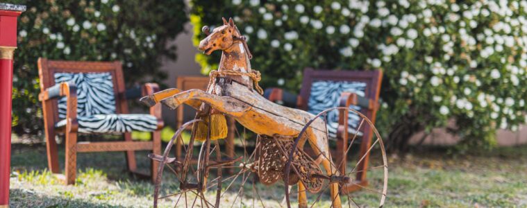 Antique metal rocking horse on wheels in open air