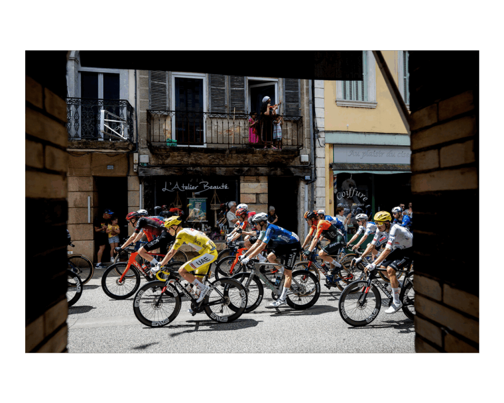 Tour de France 2024 cuclists in street of town passing shops