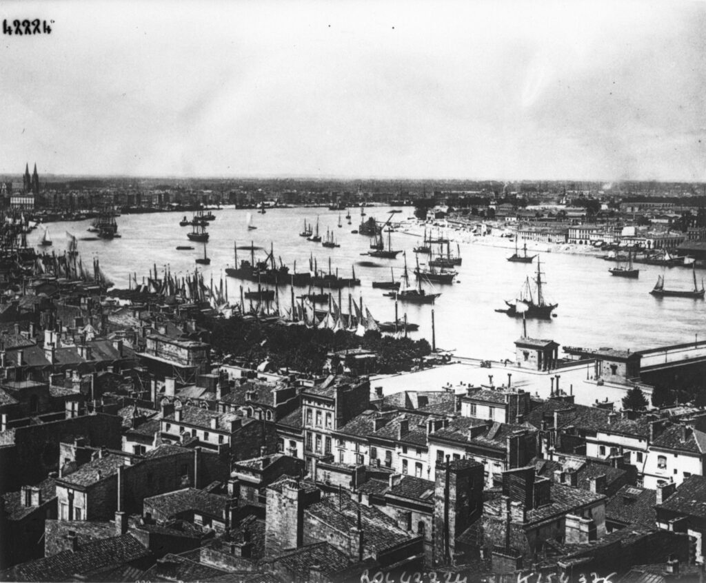 blac,k and white photo of Bordeaux port 1914 aerial view looking over buildings to river full of old boats